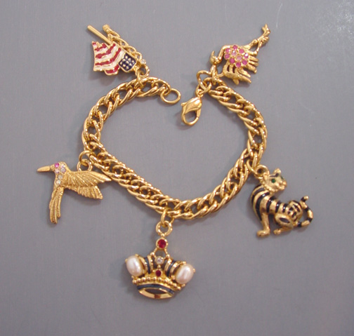 trifari bracelet. TRIFARI charm bracelet dated 1997, 7-1/2" by about 1-3/4". Charms include a flag, crown, 